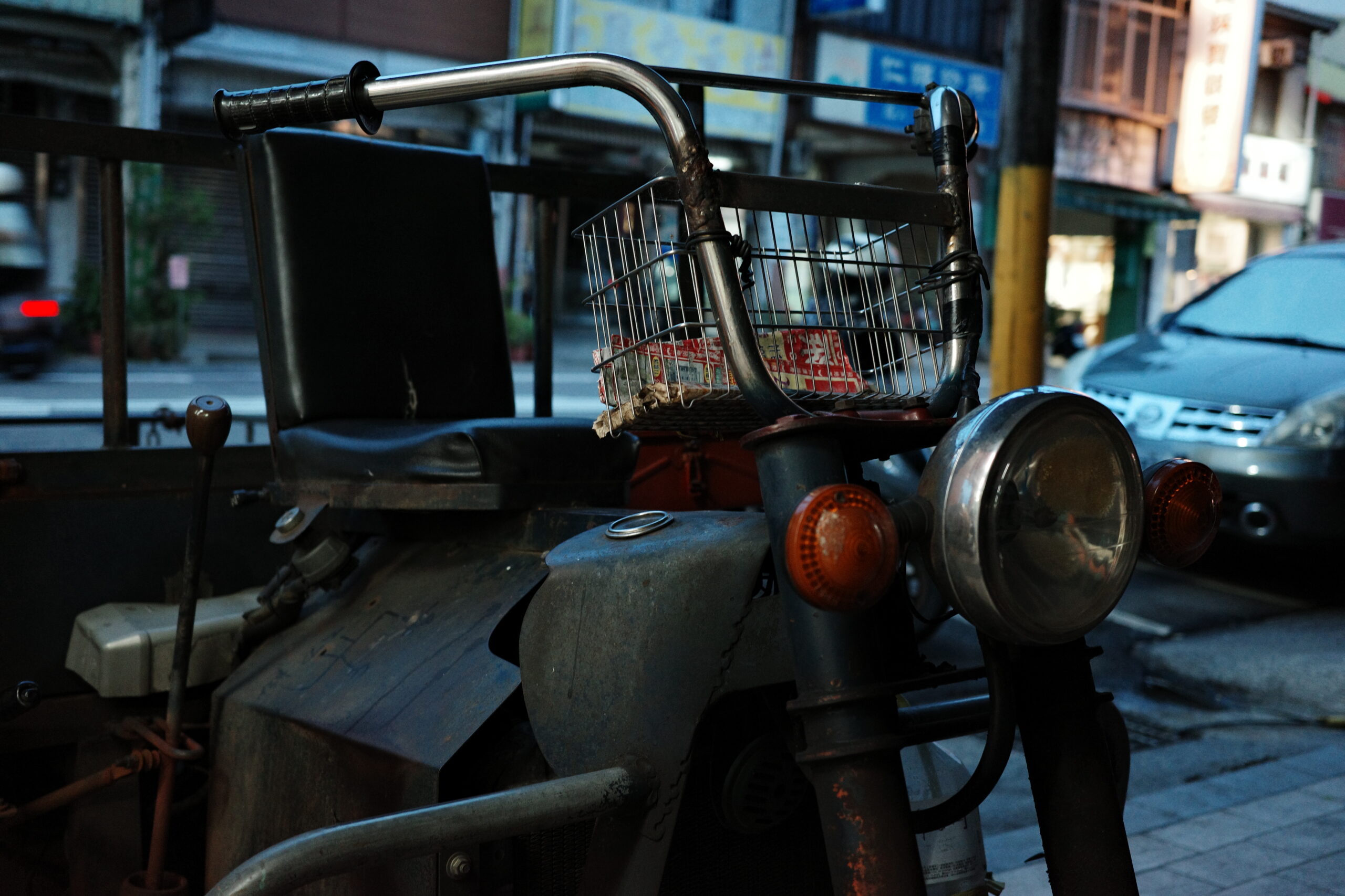 Close-up of an old motorcycle under soft urban night light.