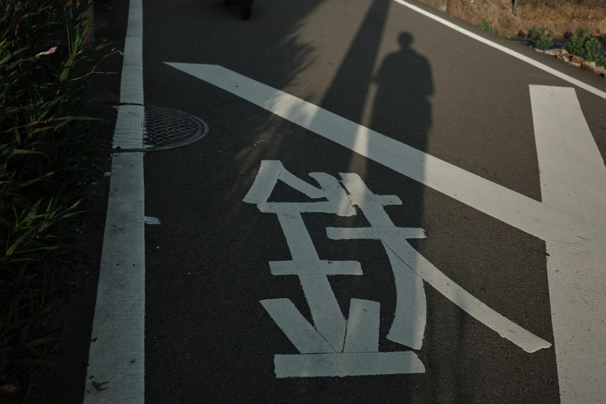 影子投射在寫著「鉄」字的地面上