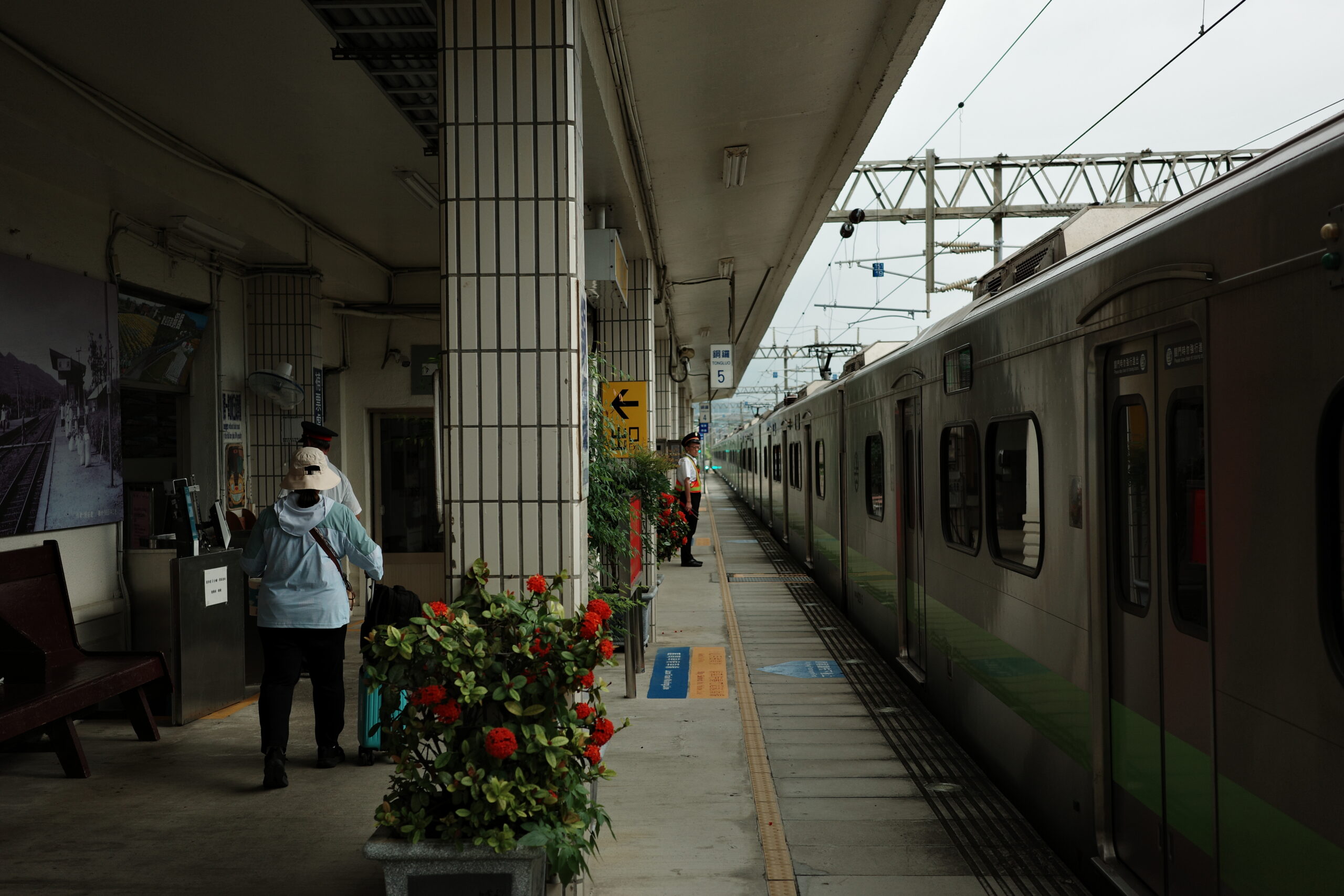 Quiet railway platform in Taiwan with a stationary train and two people waiting – Scentography style
台灣靜謐的鐵路月台，停靠的列車與等候的兩人 —— 氣韻攝記風格